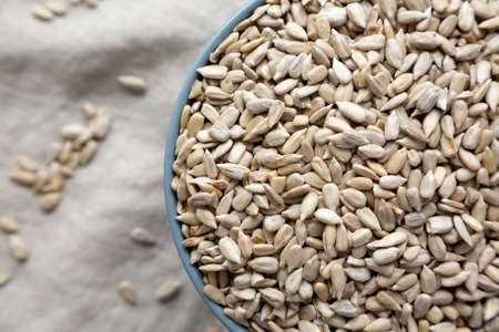 Raw Organic Sunflower Seed Kernels in a Blue Bowl, top view. Flat lay, overhead, from above. close-up.の写真素材