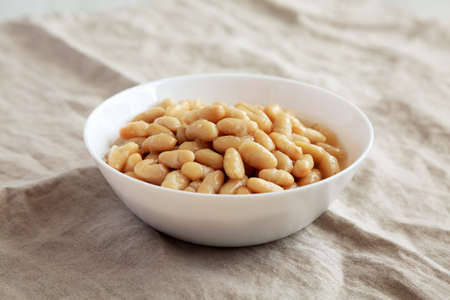 Organic White Cannellini Beans in a White Bowl, side view.