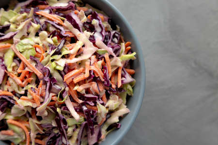 Homemade Coleslaw with Cabbage and Carrots in a Bowl, top view. Flat lay, overhead, from above....