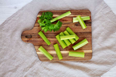 Raw Organic Celery on a wooden board, top view. Flat lay, overhead, from above.