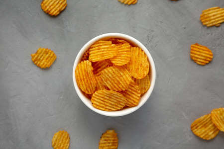 Crispy Barbeque Potato Chips in a Bowl on a gray surface, top view. Flat lay, overhead, from above.の写真素材