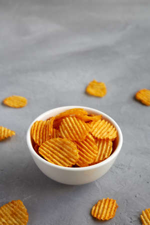 Crispy Barbeque Potato Chips in a Bowl on a gray surface, side view. copyspace.の写真素材