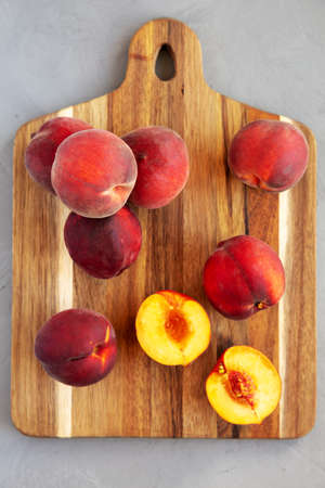 Raw Organic Yellow Peaches on a wooden board, top view. Flat lay, overhead, from above.の写真素材