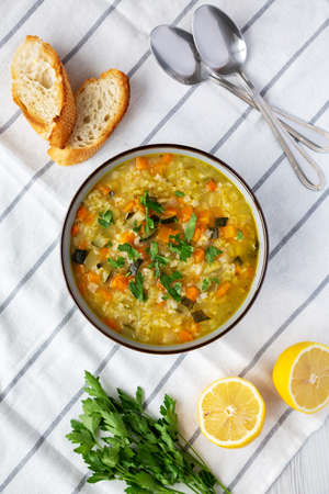 Homemade fresh lemon rice soup in a bowl, top view. Flat lay, overhead, from above.の写真素材