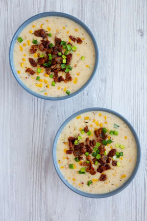 Homemade Corn Chowder with Bacon in a Bowl on a white wooden background, top view. Flat lay, overhead, from above.の写真素材