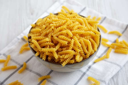 Uncooked dry girandole torsades pasta in a bowl, low angle view. close-up.の写真素材