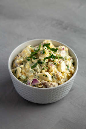 Homemade Healthy Potato Salad with Eggs in a Bowl on a gray background, side view.の写真素材