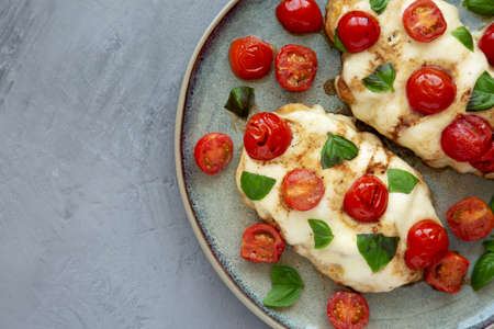 Homemade Caprese Chicken Parmesan with tomato, mozzarella and basil on a Plate, top view. Space for text.の写真素材