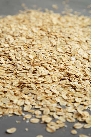 Dry Organic Rolled Oats on a gray surface, side view.の写真素材