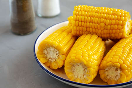 Homemade Steamed Corn on the Cob with Butter on a Plate, side view. close-up.の写真素材