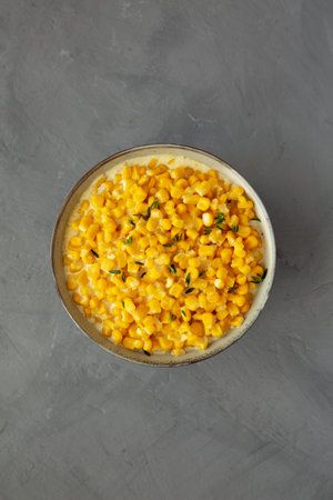 Homemade Slow Cooker Creamed Corn in a Bowl on a gray background, top view. Flat lay, overhead, from...