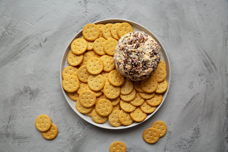 Homemade Cheese Ball with Cream Cheese and Green Onions on a Plate, top view. Flat lay, overhead, from above.