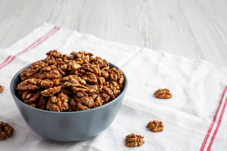 Raw Organic Walnuts in a bowl, side view. copyspace.