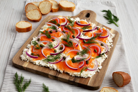 Homemade Cream Cheese Lox Bagel Board with Salmon on a white wooden background, side view.の写真素材