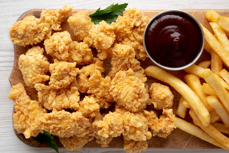 Homemade Popcorn Chicken with BBQ Sauce on a Rustic Wooden Board, top view. Flat lay, overhead, from above.の写真素材