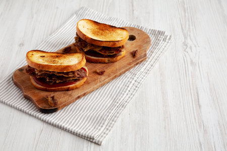Homemade British Bacon Sandwich on a rustic wooden board, side view. Space for text.の写真素材