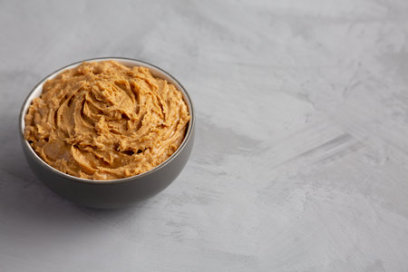 Yummy Organic Peanut Butter in a Bowl, side view. copyspace.