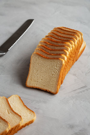 Sliced Whole Wheat White Bread on a gray background, side view.