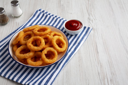 Homemade Breaded Onion Rings with Ketchup on a Plate, low angle view. Space for text.の写真素材