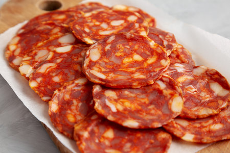 Spanish chorizo salami sausage on a rustic wooden board on a gray background, side view. close-up.の写真素材