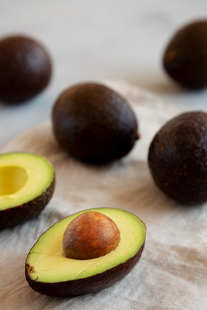 Raw Organic Hass Avocados on a gray background, side view.