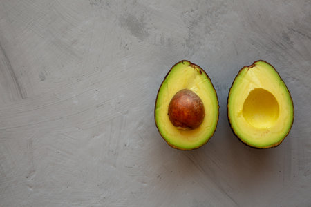 Raw Organic Hass Avocado on a gray surface, top view. Flat lay, overhead, from above. Space for...
