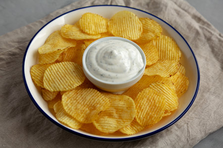 Tasty Potato Chips and Dip Appetizer on a gray background, side view.の写真素材