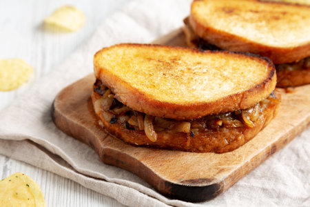 Homemade French Melt Sandwich with Caramelized Onion and Gruyure Cheese on a rustic wooden board, side view. close-up.の写真素材