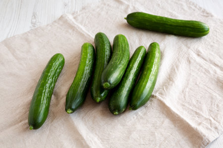 Organic Mini Baby Cucumbers on a white wooden background, side view.の写真素材