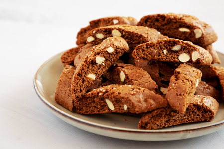 Homemade Italian Cantuccini with Almond and Coffee on a Plate on a gray surface, side view. Crispy...