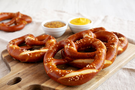Homemade Soft Bavarian Pretzels with Mustard on a wooden board, side view. Close-up.の写真素材