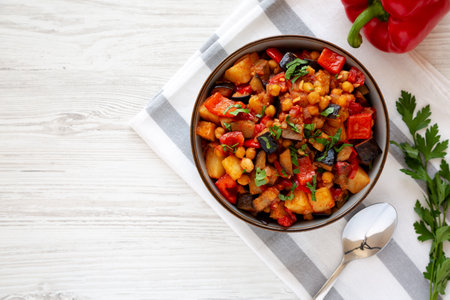 Homemade Eggplant Potato Tomato Stew with Parsley in a Bowl, top view. Flat lay, overhead, from above. Copy space.の写真素材