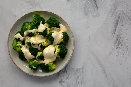 Yummy Cheesy Steamed Broccoli on a Plate, top view. Flat lay, overhead, from above. Copy space.の写真素材