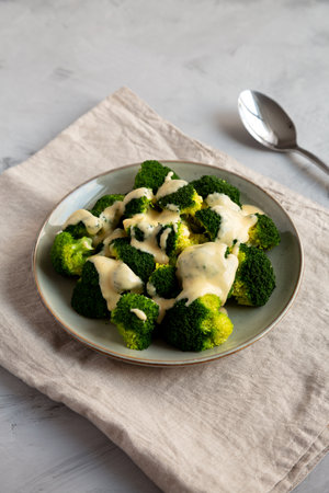 Yummy Cheesy Steamed Broccoli on a Plate, side view.の写真素材