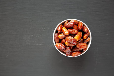 Organic Dry Deglet Nour Dates in a Bowl, top view. Flat lay, overhead, from above. Copy space.