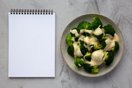 Yummy Cheesy Steamed Broccoli on a Plate, top view. Flat lay, overhead, from above. Copy space.の写真素材