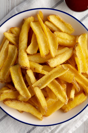 Homemade French Fries on a Plate on a white wooden background, top view. Close-up.の写真素材