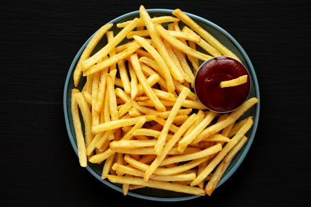 Homemade French Fries with Ketchup on a Plate, top view. Flat lay, overhead, from above.