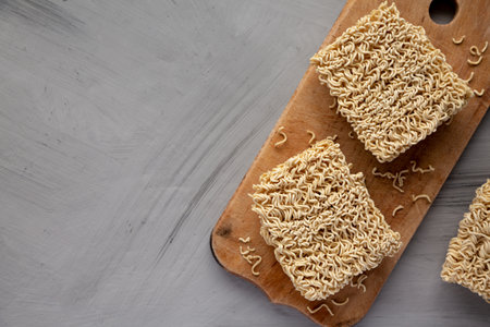 Dry Ramen Noodles on a wooden board, top view. Flat lay, overhead, from above. Copy space.の写真素材