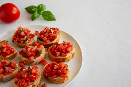 Homemade Bruschetta with Basil and Tomatoes on a Plate, side view. Copy space.の写真素材