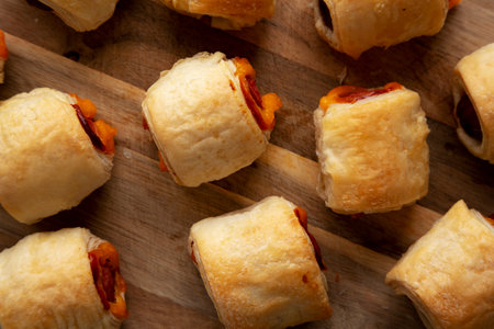 Homemade Pigs in a Blanket with Ketchup and Mustard on a Wooden Board, top view. Flat lay, overhead, from above.の写真素材