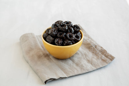Raw Dried Plum Prunes in a Bowl, side view.の写真素材
