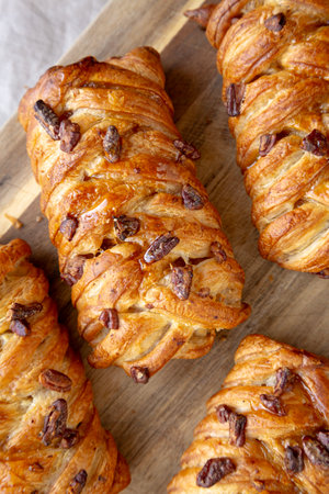 Homemade Maple Pecan Danish Pastry on a wooden board, top view. Flat lay, overhead, from above.の写真素材