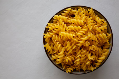Raw Dry Organic Fusillini Pasta in a Bowl, top view. Copy space.の写真素材