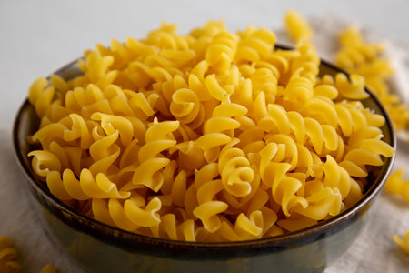 Raw Dry Organic Fusillini Pasta in a Bowl, side view.の写真素材