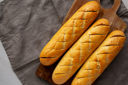 Homemade French Baguette with Garlic Filling on a wooden board, top view. Copy space.の写真素材