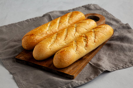 Homemade French Baguette with Garlic Filling on a wooden board, side view.の写真素材