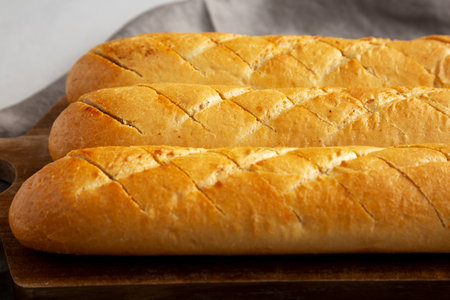 Homemade French Baguette with Garlic Filling on a wooden board, side view.の写真素材