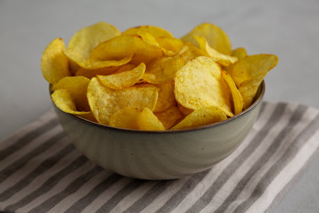 Homemade Kettle Cooked Potato Chips with Salt in a Bowl, side view.の写真素材