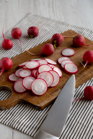 Raw Red Radish Slices on a Cutting Board, side view.の写真素材